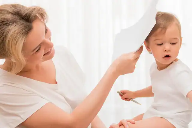 Mother checking toddler’s temperature with thermometer