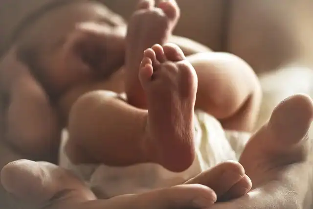 Sleeping newborn cradled in adult hands