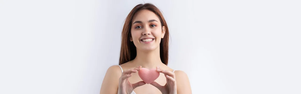 Smiling woman holding pink heart shape