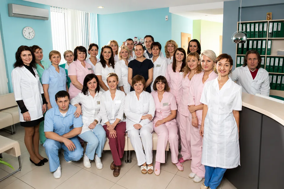 Medical staff group photo in a modern clinic setting.